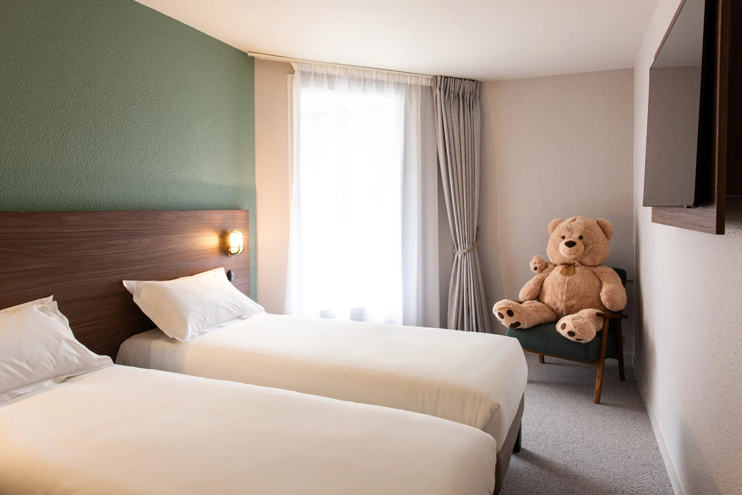 Suite familiale moderne de la Maison OBONO avec deux lits jumeaux, nounours géant et télévision murale