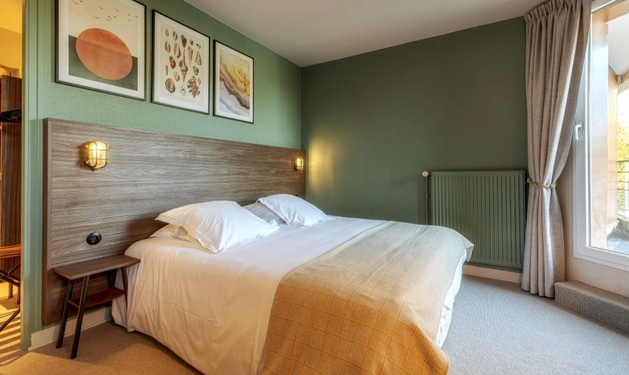 Doppelzimmer mit Holzkopfteil, Wanddekoration und Zugang zu einem Balkon/einer Terrasse.