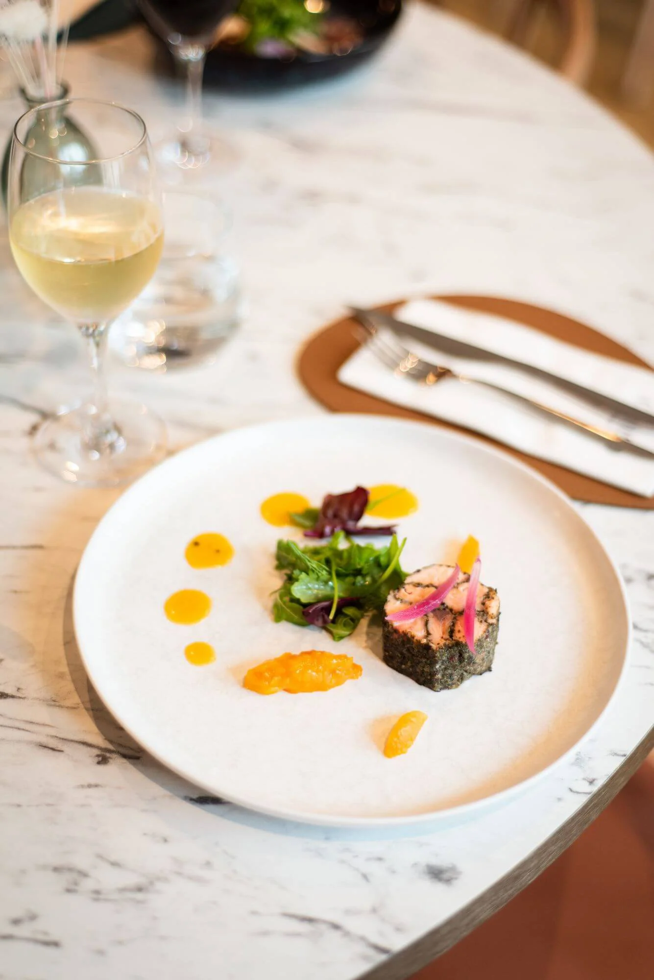 Assiette gastronomique du restaurant La Table OBONO : pavé de poisson en croûte de nori, sauce agrumes, mesclun et vin blanc